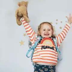Uśmiechnięta dziewczynka z pluszowym misiem w ręku, gotowa na przygodę. Jej radosna mina sugeruje, że trudna adaptacja w przedszkolu już za nią!