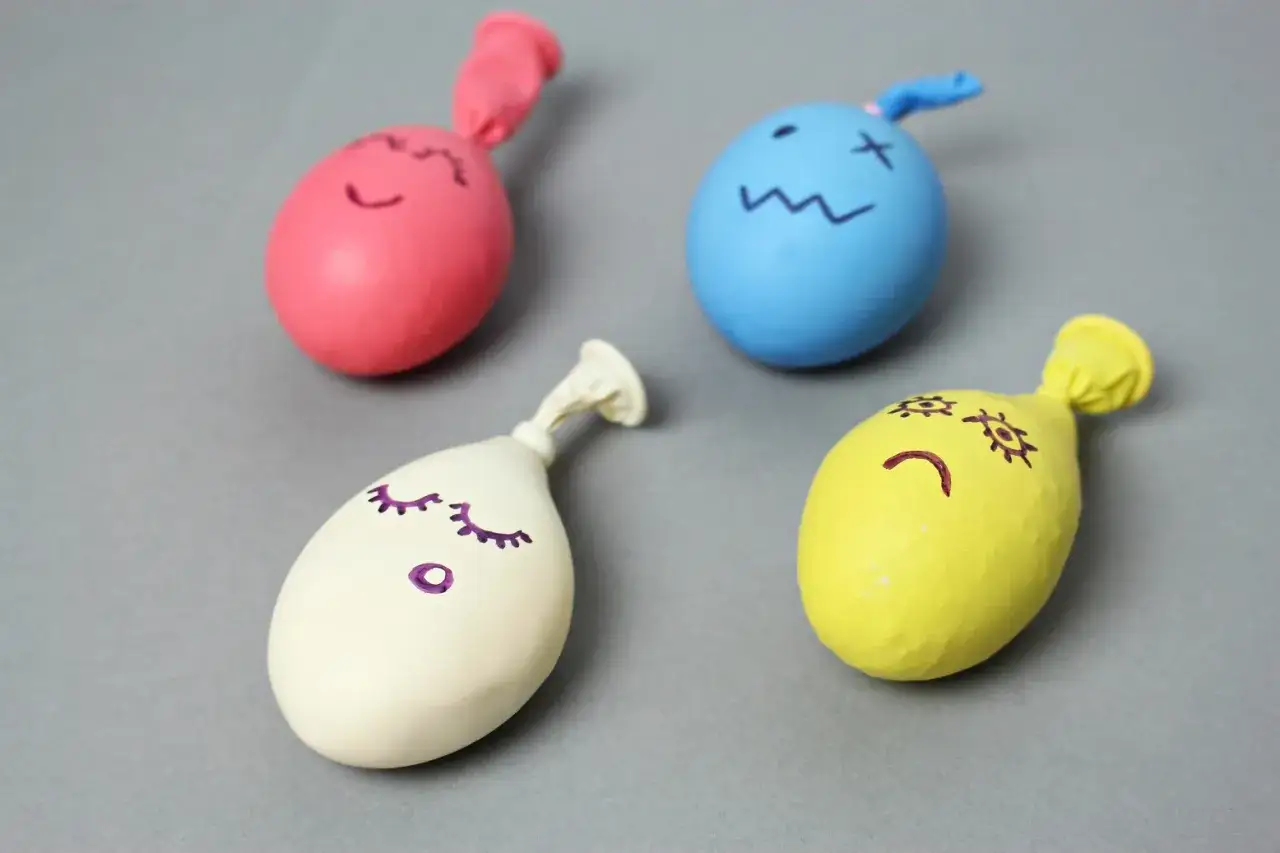 Kolorowe balony z narysowanymi buźkami – idealne, by pokazać, jak zrobić zabawki antystresowe.