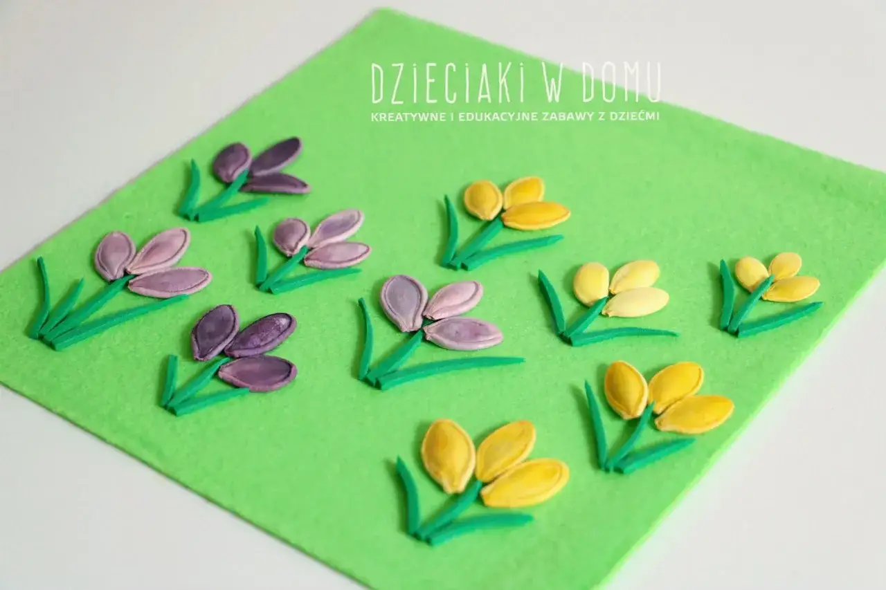Kwiatki z pestek dyni i zielonych pasków pianki na zielonym filcu. Wiosenne prace plastyczne dla dzieci.